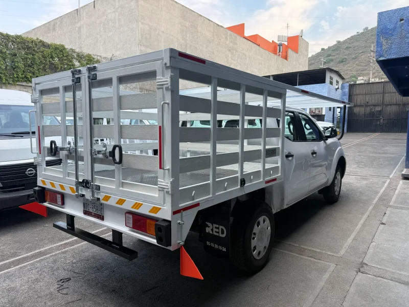 Pickup con carrocería especial de redilas altas vista lateral izquierda en calle urbana