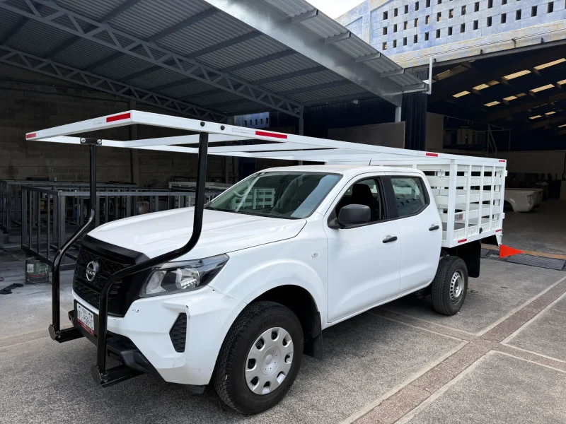 Nissan Frontier blanca con carrocería especial de redilas vista frontal lateral