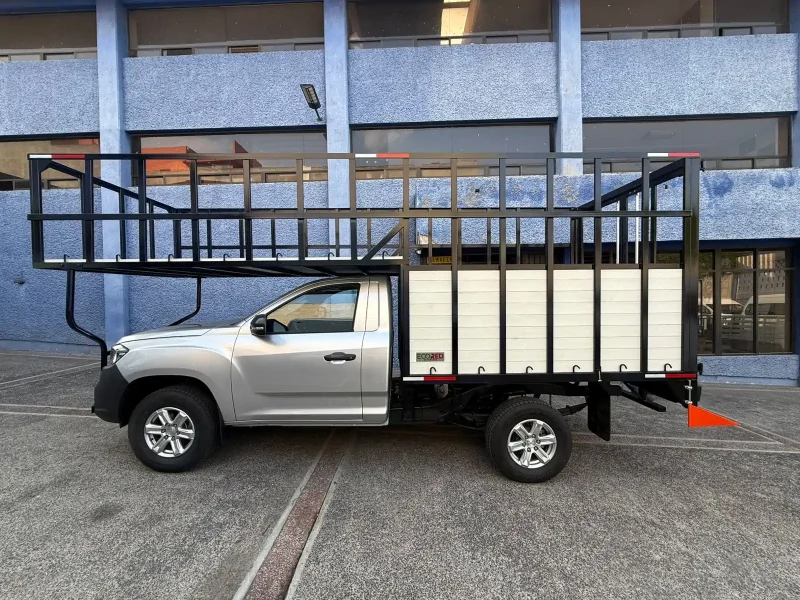 Pickup con carrocería especial de redilas mixtas vista lateral en patio