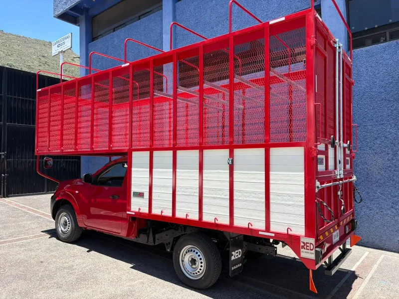 Camión rojo con carrocería especial de redilas abiertas vista trasera lateral