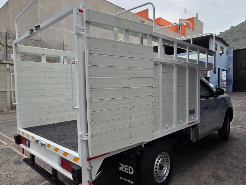 Vista lateral izquierda de caja de redilas abiertas con copete en camioneta de trabajo