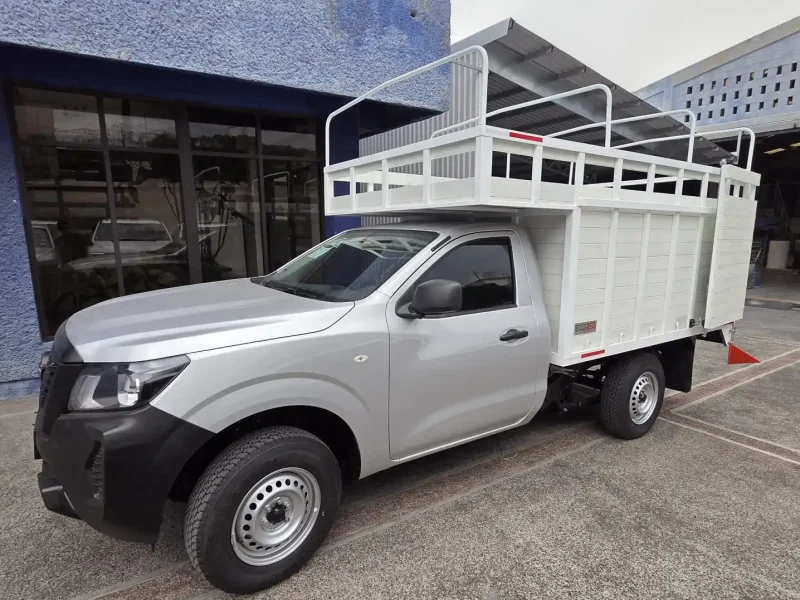 Vista frontal lateral de pickup con carrocería de redilas abiertas y copete alto