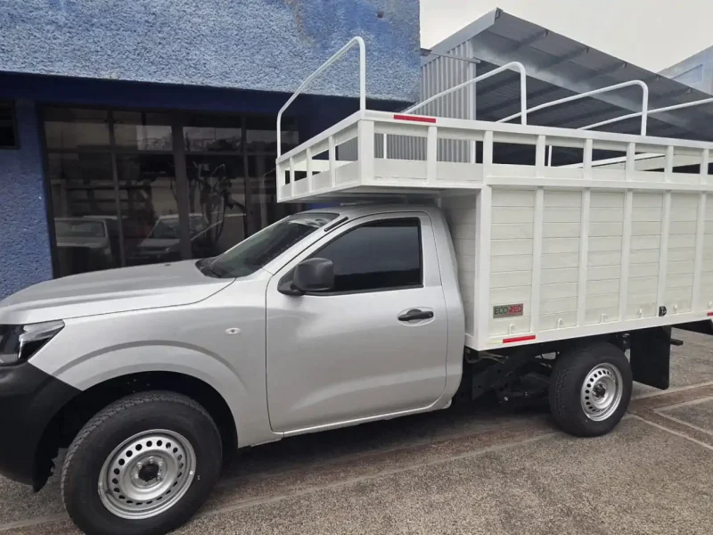 Pickup gris con caja de redilas abiertas vista lateral izquierda en exteriores