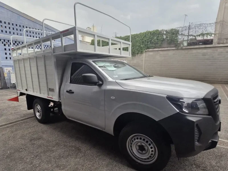 Camioneta pickup con caja de redilas abiertas y copete vista lateral derecha